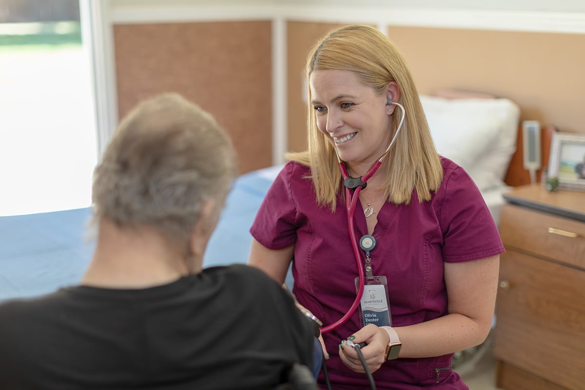 A nurse checking a mans blood pressure at Marysville Post Acute